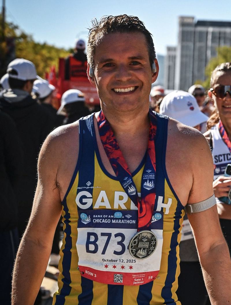 Gareth Hiron smiling with his medal just after finishing the 2025 Chicago Marathon